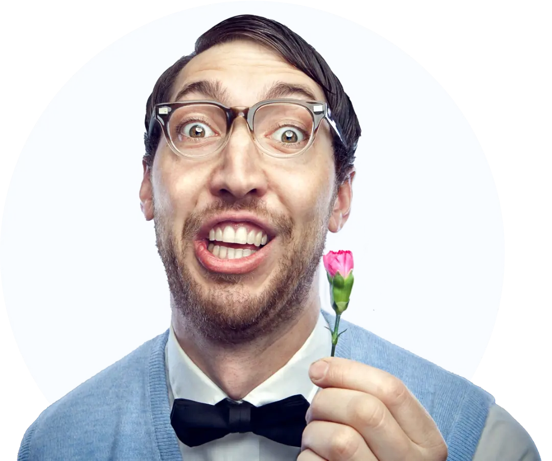 A candid headshot of a man with glasses holding a small pink flower